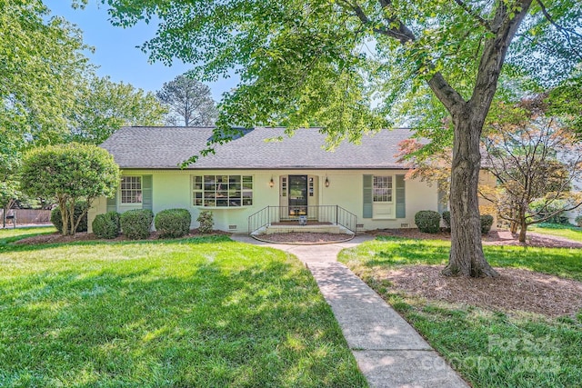 single story home featuring a front lawn, roof with shingles, and stucco siding