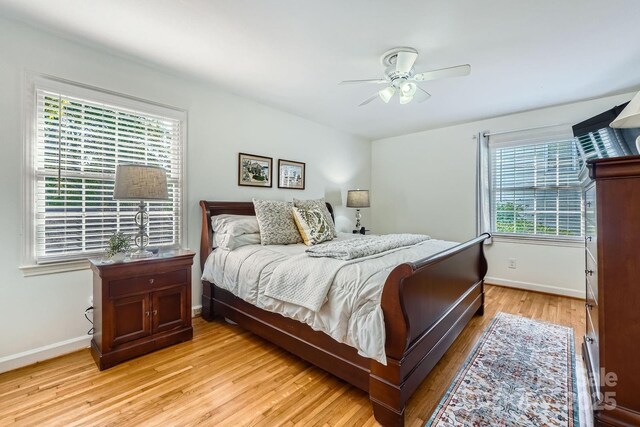 bedroom with light wood-style floors, baseboards, and ceiling fan