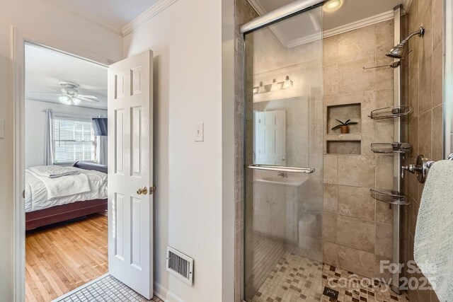 ensuite bathroom featuring crown molding, ceiling fan, ensuite bath, visible vents, and a stall shower