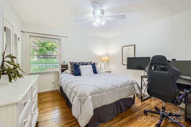 bedroom with a ceiling fan, baseboards, and wood finished floors