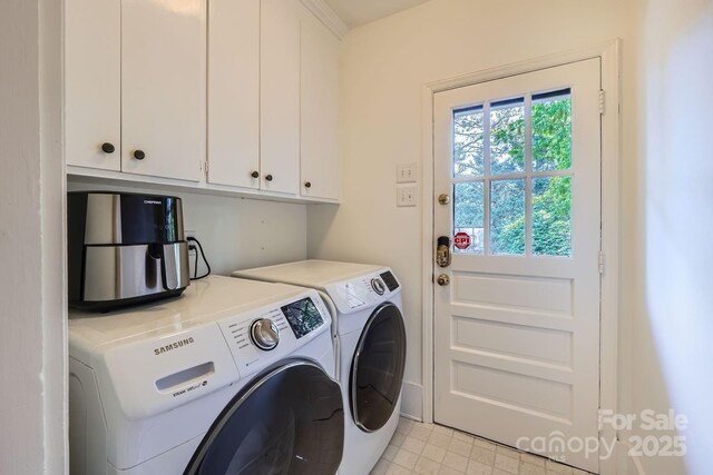 clothes washing area featuring washing machine and dryer and cabinet space