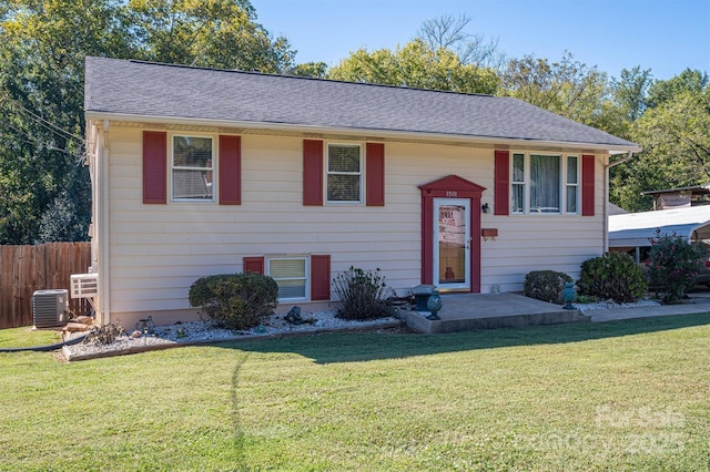 raised ranch featuring cooling unit and a front lawn