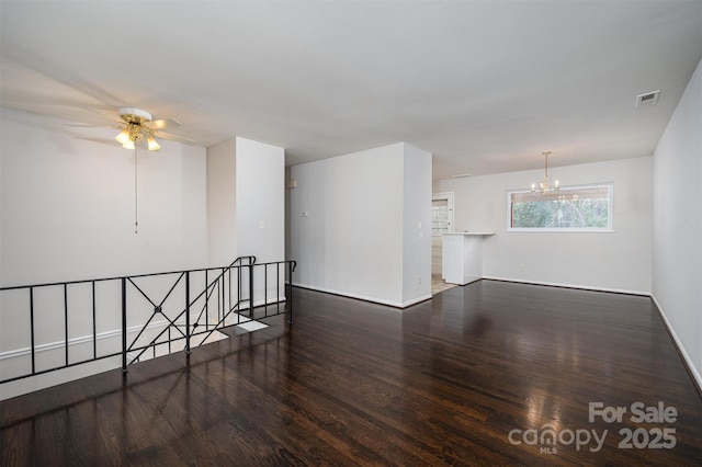 unfurnished room with dark hardwood / wood-style flooring and ceiling fan with notable chandelier