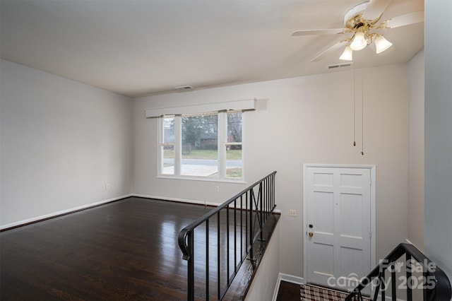 stairs with hardwood / wood-style flooring and ceiling fan