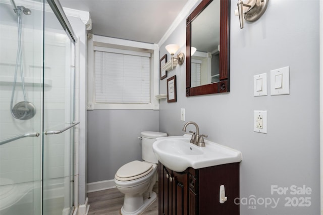 bathroom with an enclosed shower, vanity, hardwood / wood-style flooring, and toilet