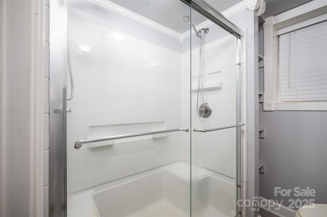 bathroom with a shower with door, ornamental molding, and toilet