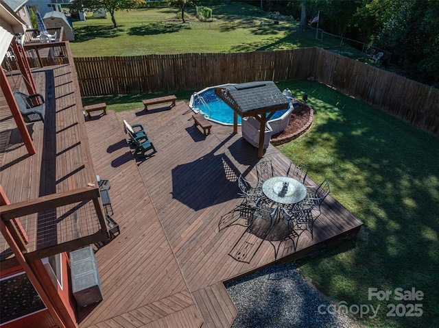 wooden terrace featuring a fenced in pool and a lawn