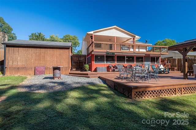 back of house featuring a deck and a lawn