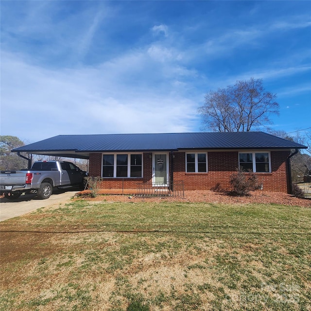 ranch-style house with a carport, concrete driveway, brick siding, and a front lawn