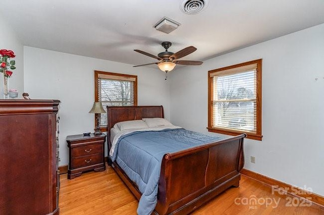 bedroom with a ceiling fan, visible vents, light wood-style flooring, and baseboards