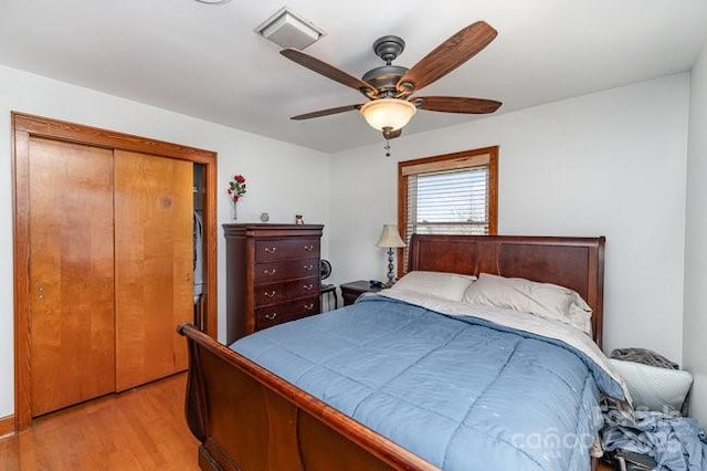 bedroom with light wood-type flooring, visible vents, and ceiling fan