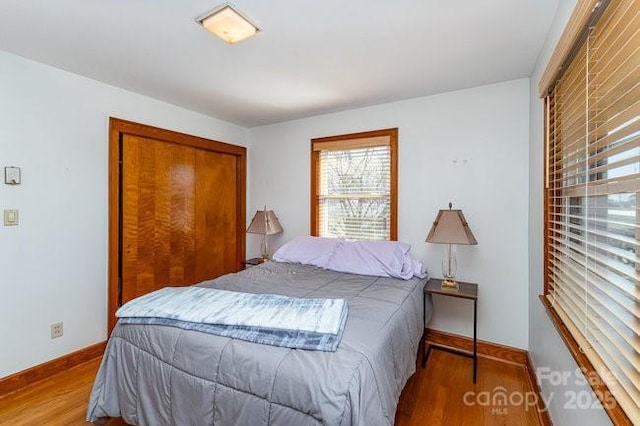 bedroom featuring light wood finished floors and baseboards