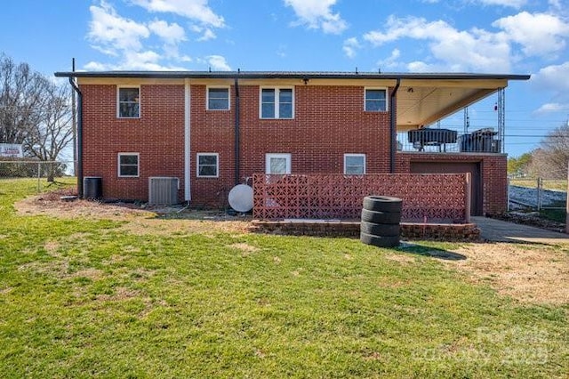 back of house featuring cooling unit, brick siding, a lawn, and fence