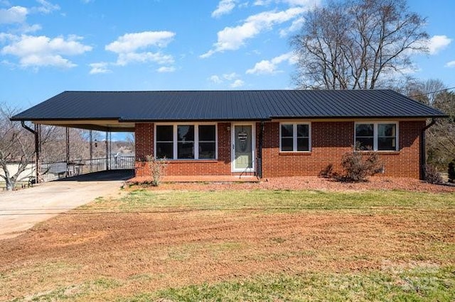 single story home featuring metal roof, an attached carport, and a front lawn