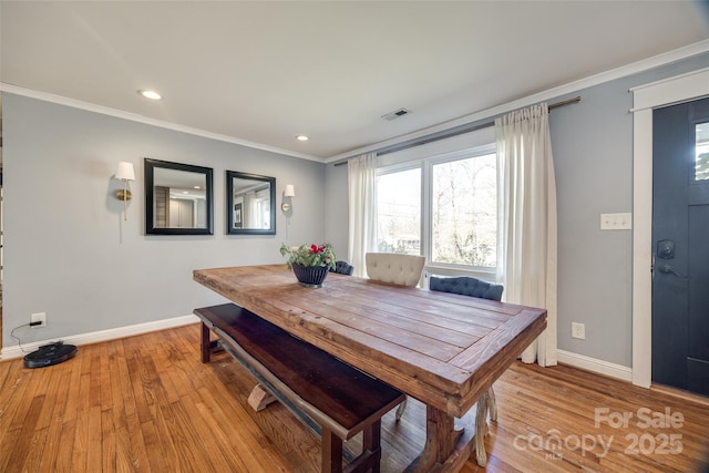 dining room with light hardwood / wood-style flooring and ornamental molding