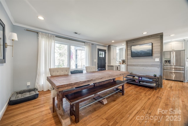 dining room featuring crown molding and light hardwood / wood-style floors