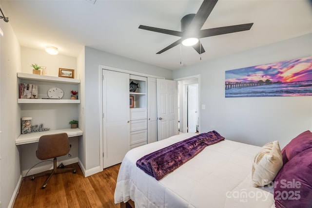 bedroom featuring ceiling fan, built in desk, light hardwood / wood-style floors, and a closet