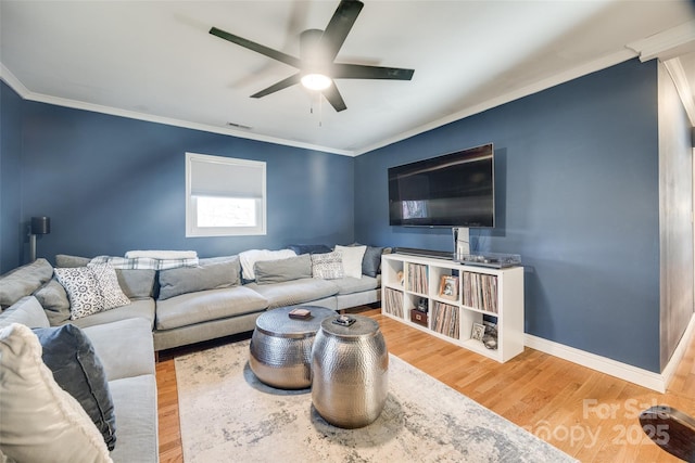 living room with wood-type flooring, ornamental molding, and ceiling fan