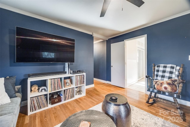 living room featuring hardwood / wood-style flooring, ceiling fan, and ornamental molding