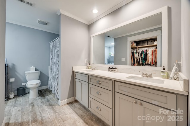 bathroom with hardwood / wood-style flooring, vanity, ornamental molding, curtained shower, and toilet