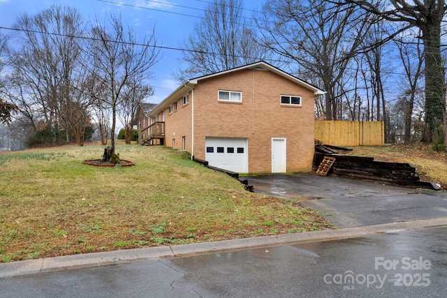 view of side of property featuring a garage and a lawn