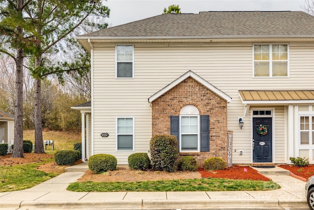 multi unit property featuring brick siding and roof with shingles