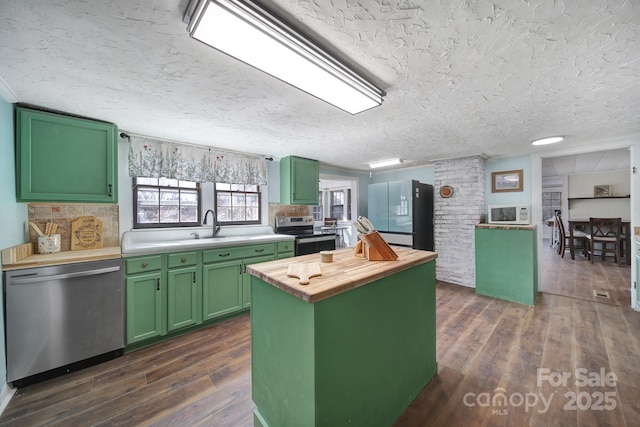 kitchen with stainless steel appliances, a center island, butcher block countertops, and green cabinets