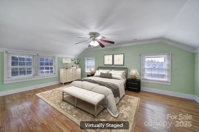 bedroom featuring hardwood / wood-style floors, lofted ceiling, and multiple windows