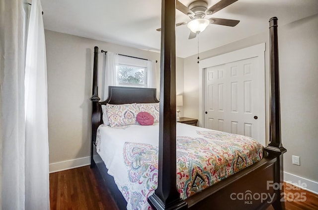 bedroom with dark wood-type flooring, ceiling fan, and a closet