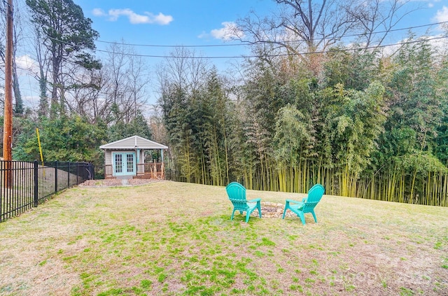 view of yard with an outdoor fire pit, an outbuilding, and french doors