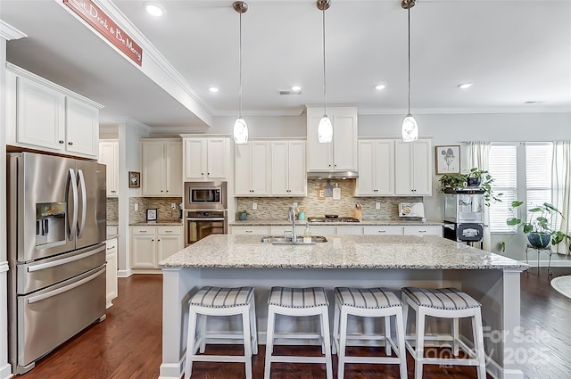14827 Batteliere Dr, Charlotte, NC 28278 - kitchen with an island with sink, light stone counters, decorative light fixtures, stainless steel appliances, and white cabinetry