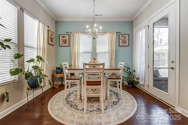 14827 Batteliere Dr, Charlotte, NC 28278 - dining space with a notable chandelier, dark wood-type flooring, visible vents, baseboards, and ornamental molding