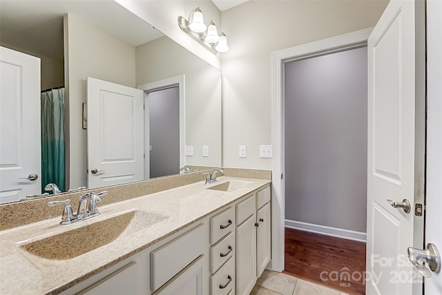 14827 Batteliere Dr, Charlotte, NC 28278 - bathroom featuring double vanity, baseboards, a sink, and tile patterned floors
