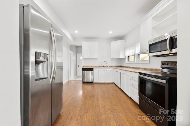 kitchen featuring white cabinetry, appliances with stainless steel finishes, sink, and light hardwood / wood-style floors