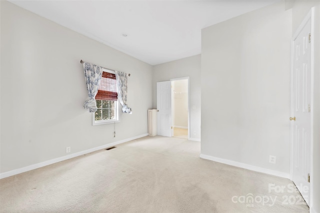 unfurnished room with light colored carpet