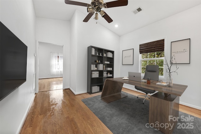 office space featuring ceiling fan, hardwood / wood-style floors, and high vaulted ceiling