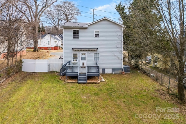 rear view of house featuring a wooden deck and a lawn