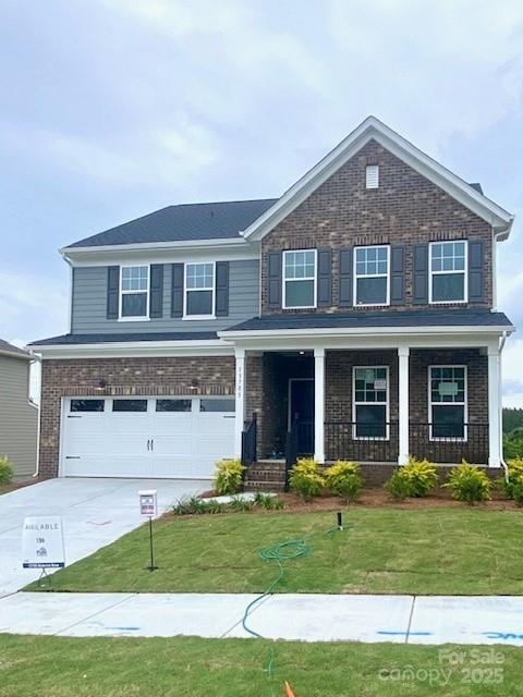13705 Roderick Dr Unit 194, Huntersville, NC 28078 - view of front of house featuring brick siding, concrete driveway, an attached garage, a front yard, and a porch
