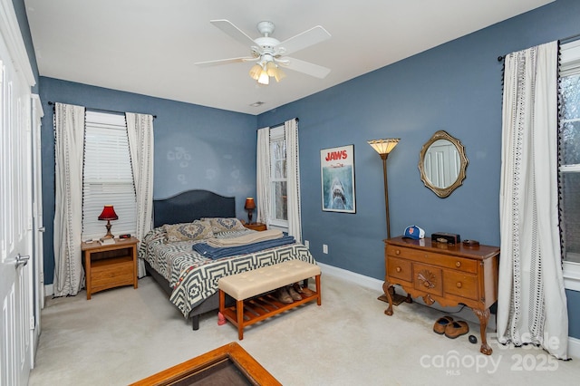 bedroom with light colored carpet, ceiling fan, and baseboards