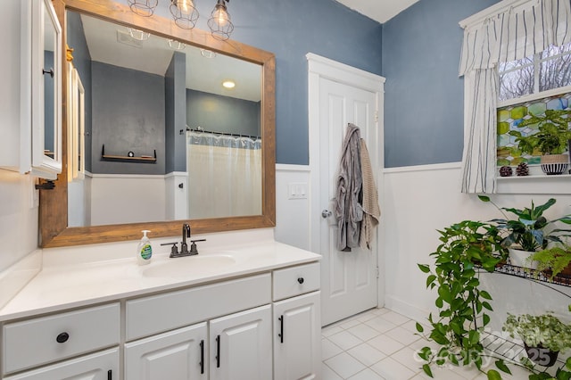 full bath with a shower with shower curtain, vanity, and tile patterned floors