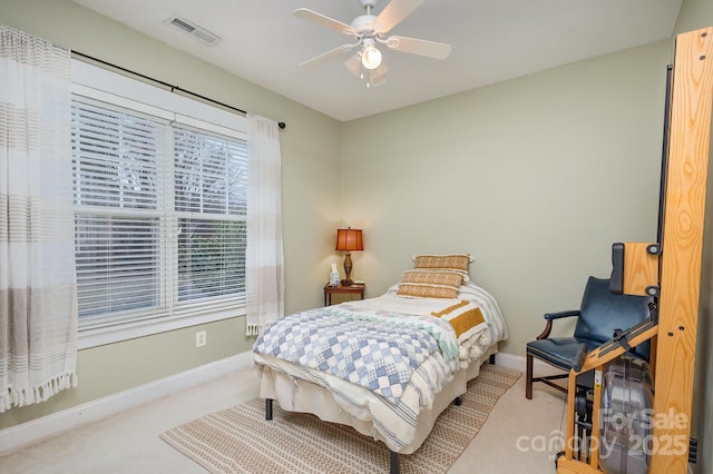 bedroom featuring ceiling fan, light colored carpet, visible vents, and baseboards