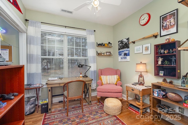 office with baseboards, ceiling fan, visible vents, and wood finished floors