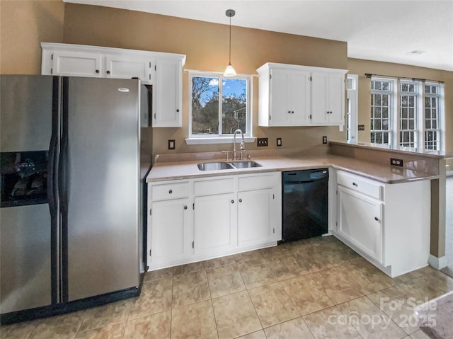 kitchen featuring a sink, light countertops, stainless steel refrigerator with ice dispenser, dishwasher, and pendant lighting