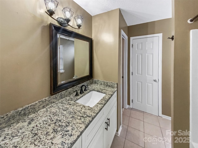 bathroom with tile patterned flooring, vanity, and baseboards