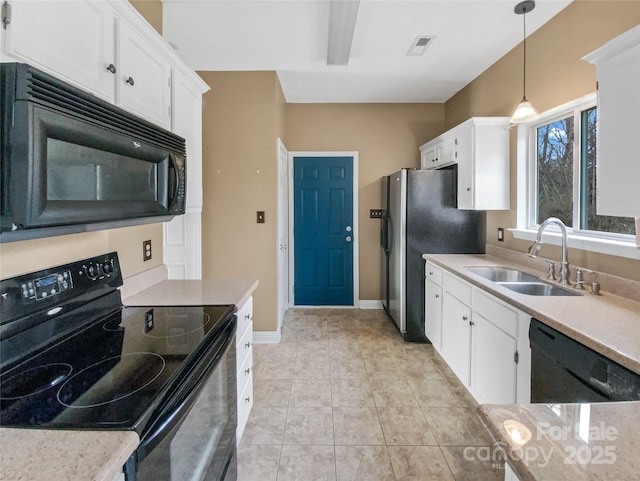 kitchen featuring a sink, white cabinets, light countertops, black appliances, and decorative light fixtures