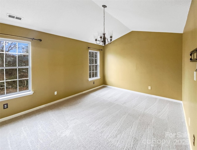 carpeted spare room with lofted ceiling, baseboards, visible vents, and a notable chandelier