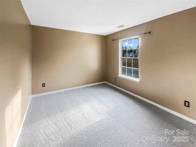 empty room featuring baseboards, visible vents, and carpet flooring