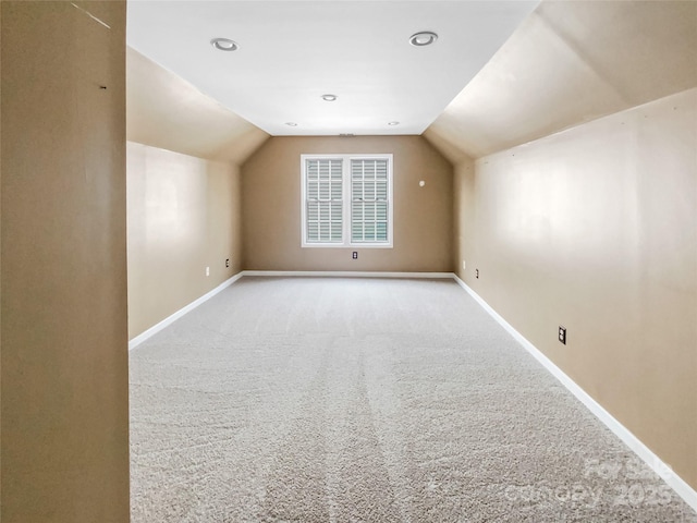 additional living space with vaulted ceiling, carpet, and baseboards