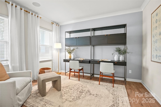 living area with crown molding and hardwood / wood-style floors