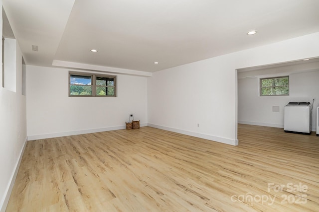 spare room with recessed lighting, washer / clothes dryer, wood finished floors, and a healthy amount of sunlight